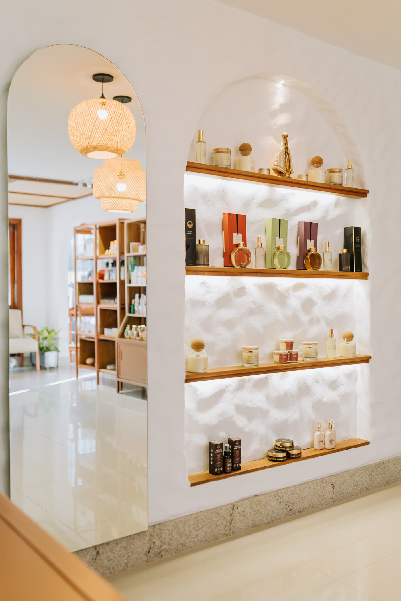 Recepção do Flow com nichos em arco e prateleiras de produtos