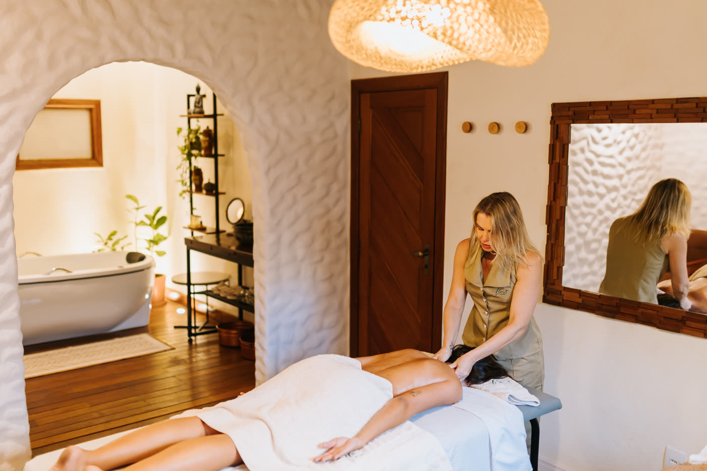 Sala de massagem do Flow com maca, espelho e banheira de imersão ao fundo